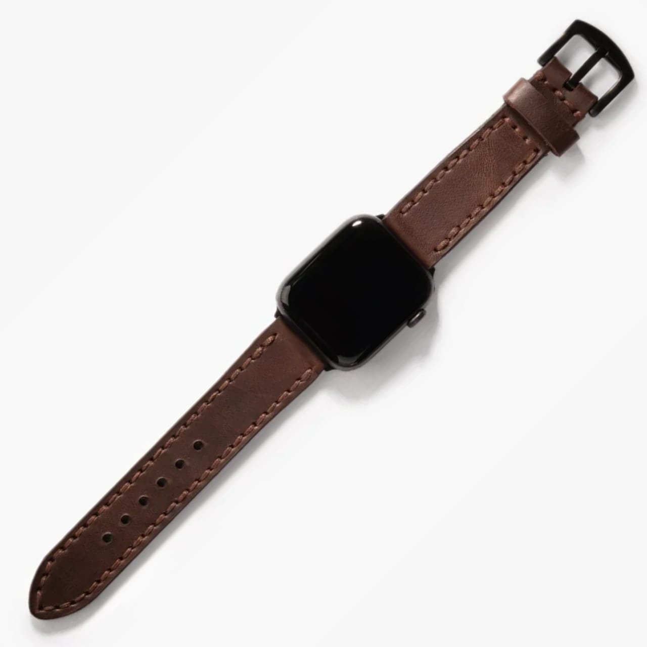 Çift Katlı Deri Apple Watch Kayışı – Kahve, doğal ışıkta masa üzerinde açık şekilde sergileniyor